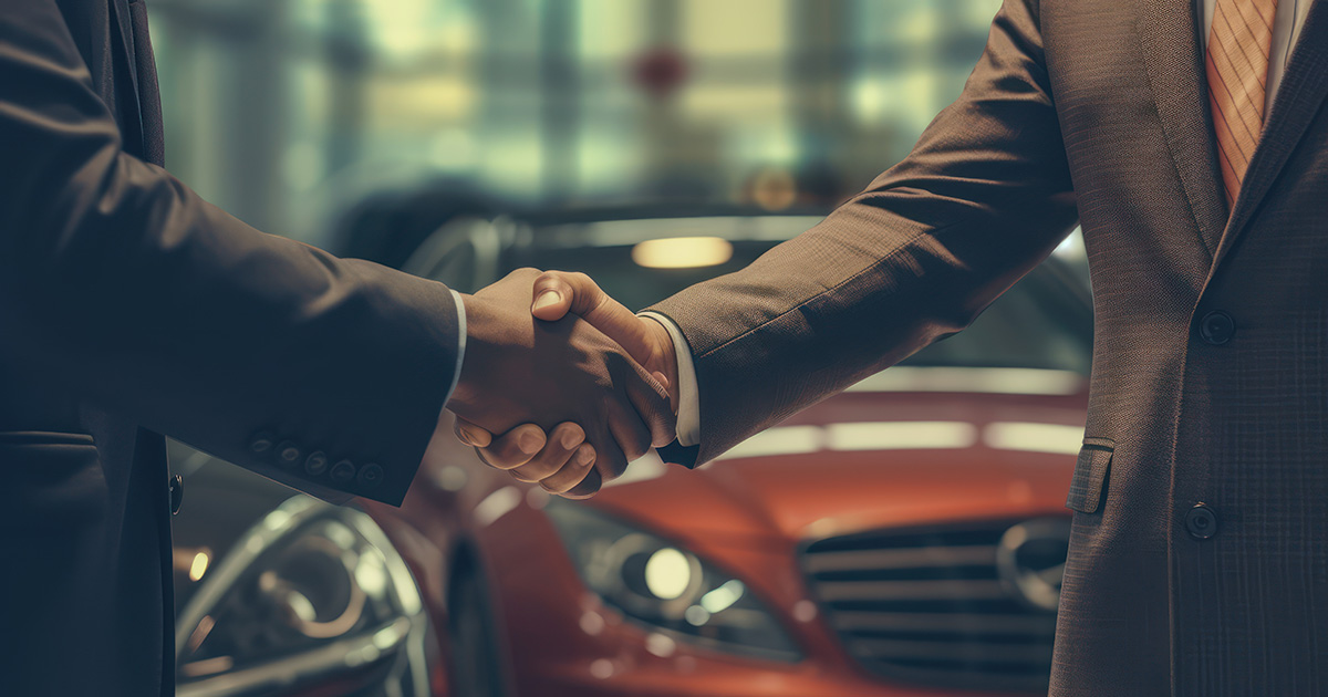 Zwei Männer geben sich einen Handschlag nach dem Autokauf